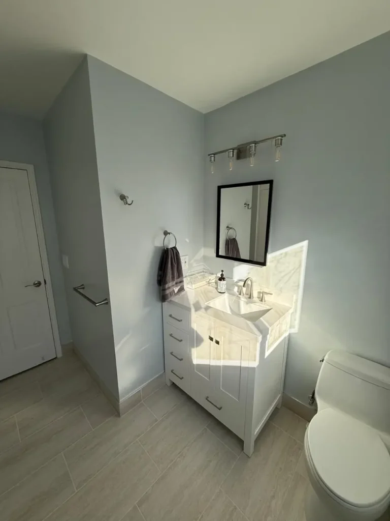 small bathroom with mirror and beige coloring