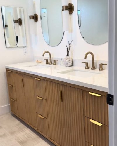 fluted wood bathroom vanity with gold fixtures