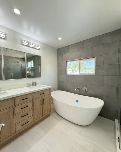 gray bathroom tiling with bathtub and vanity
