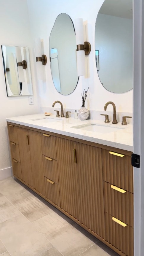 fluted wood bathroom vanity with gold fixtures