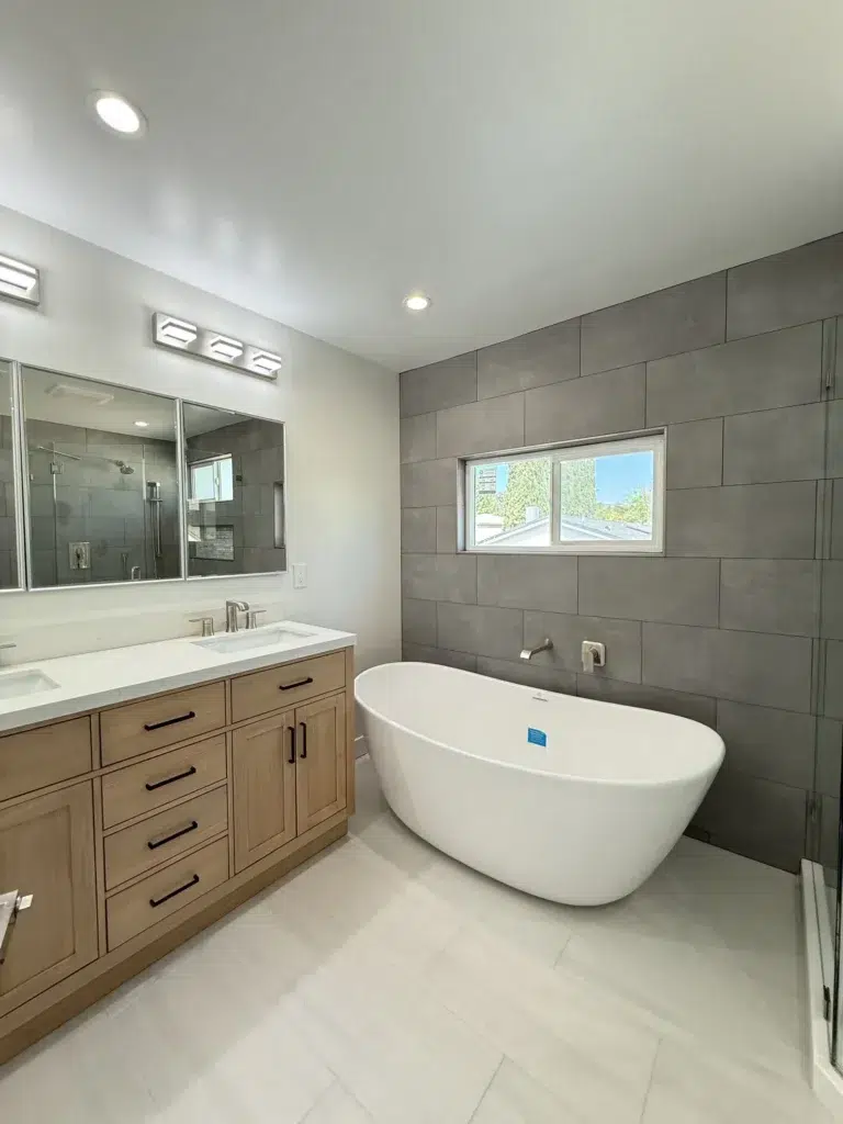 gray bathroom tiling with bathtub and vanity