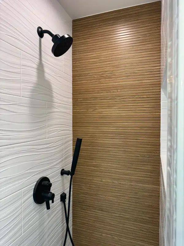 Modern shower with black fixtures and wood accent tile wall
